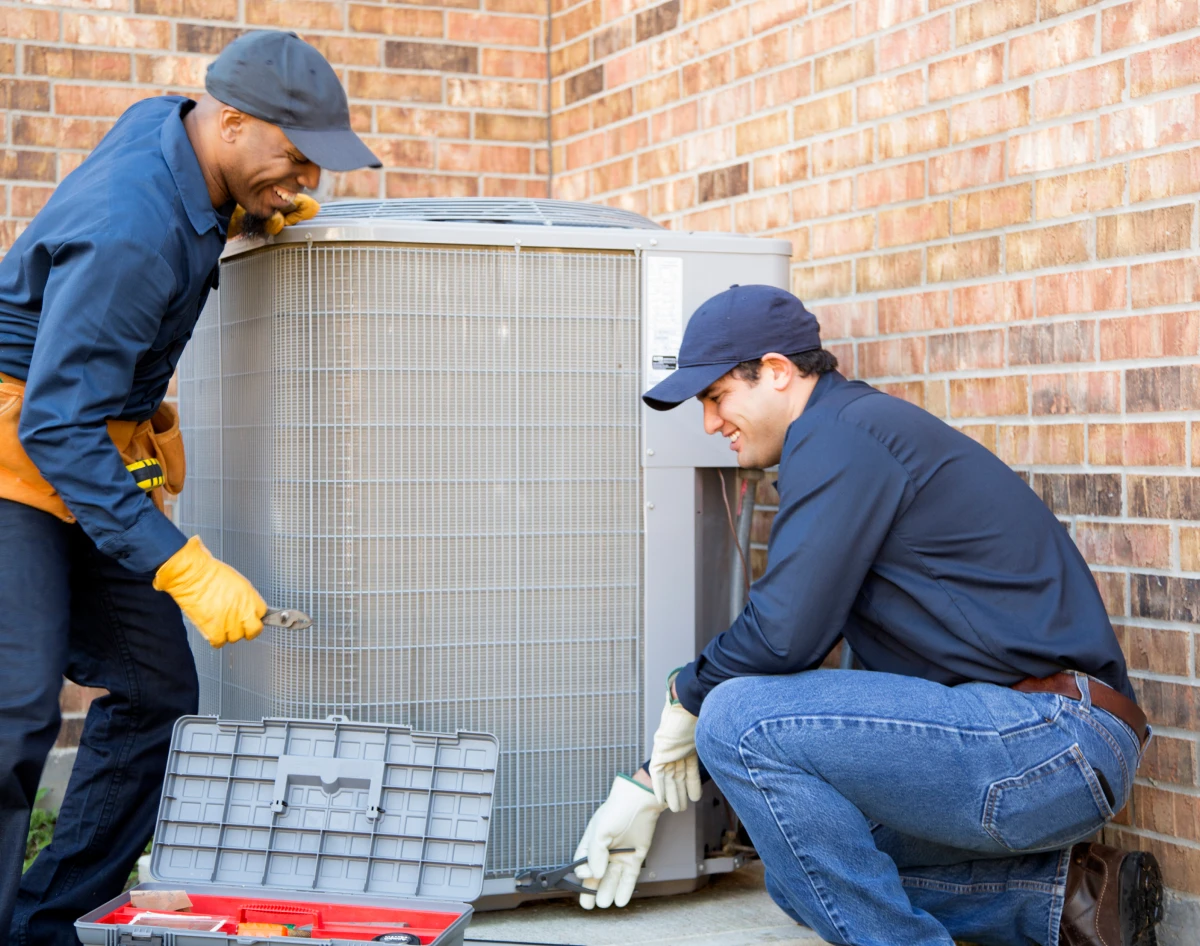 Technicians repairing outdoor air conditioning unit