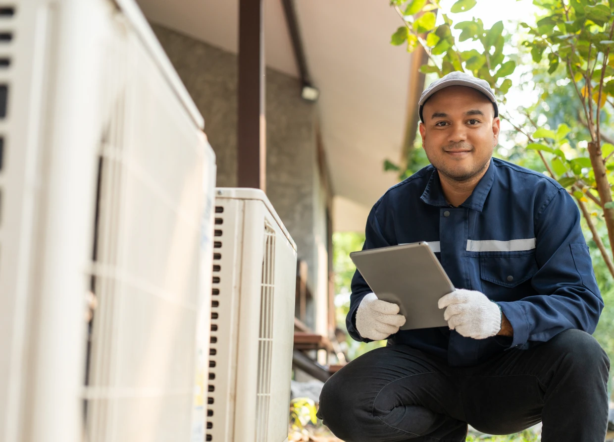 Maintenance worker examining outdoor AC unit
