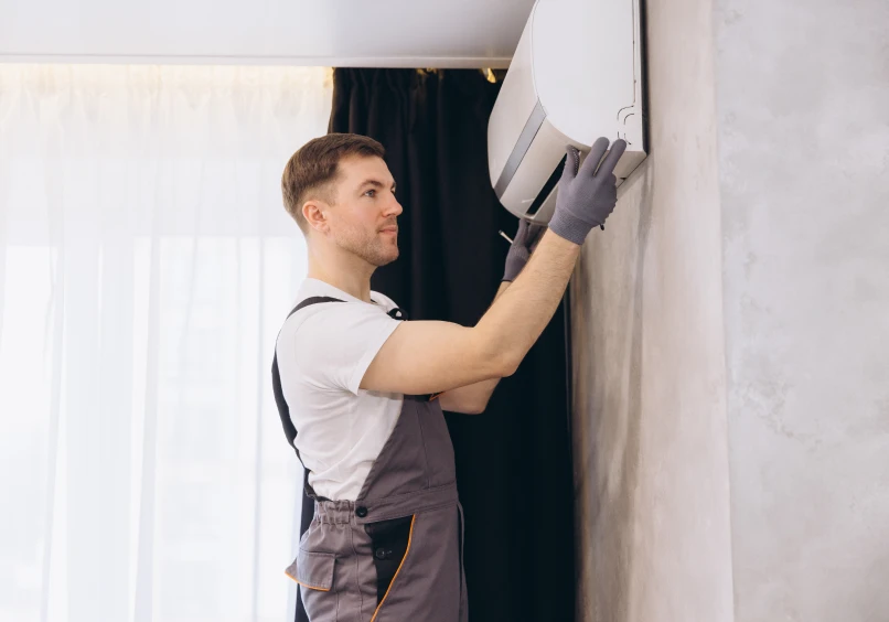 Man fixing wall-mounted AC