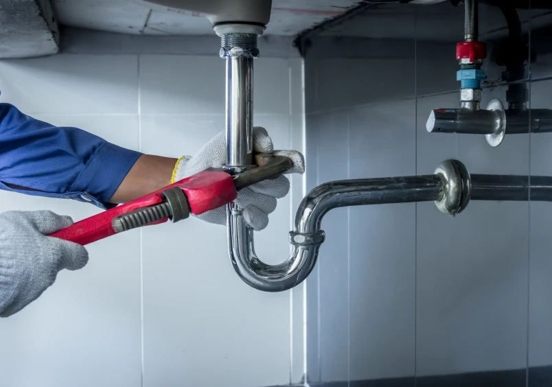 Repairing sink plumbing with wrench